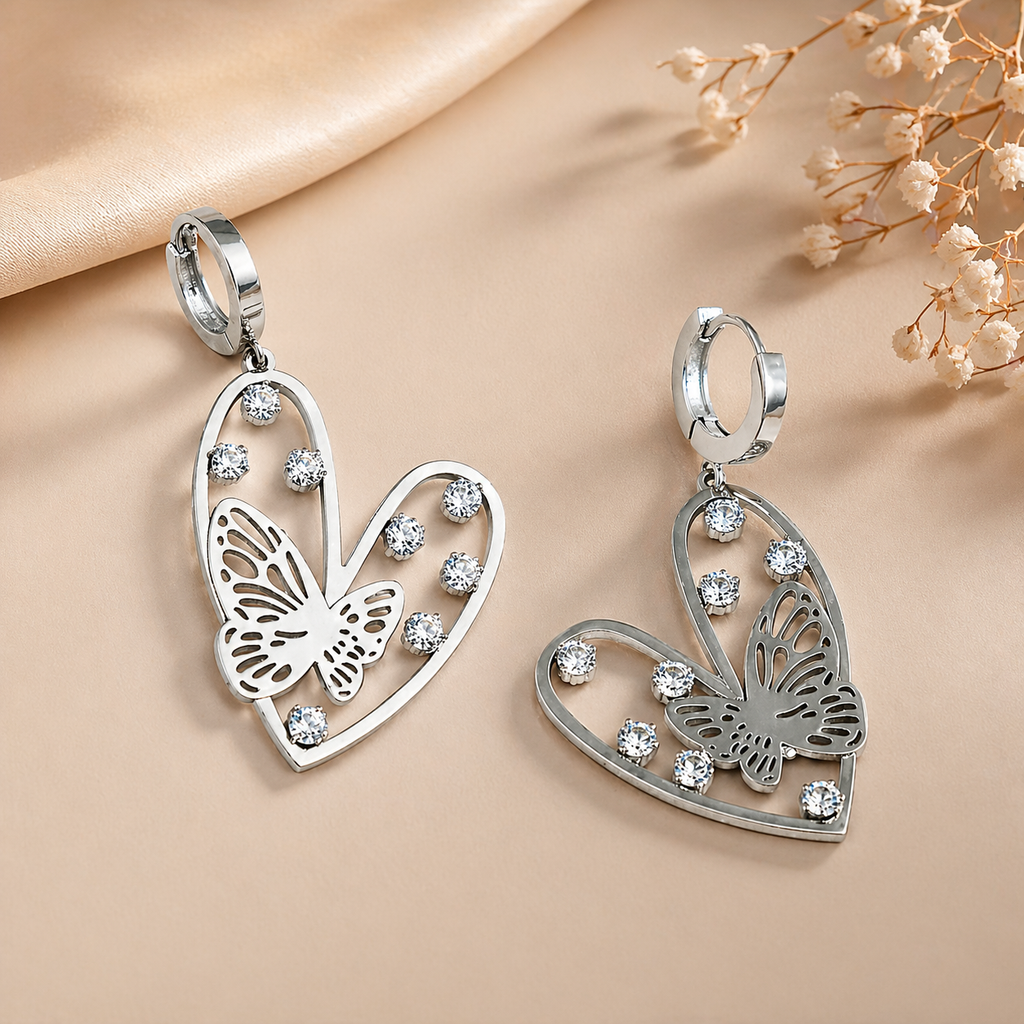 Silver-Toned Heart And Butterfly Drop Huggie Earrings With Rhinestone Accents.