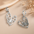 Silver-Toned Heart And Butterfly Drop Huggie Earrings With Rhinestone Accents.