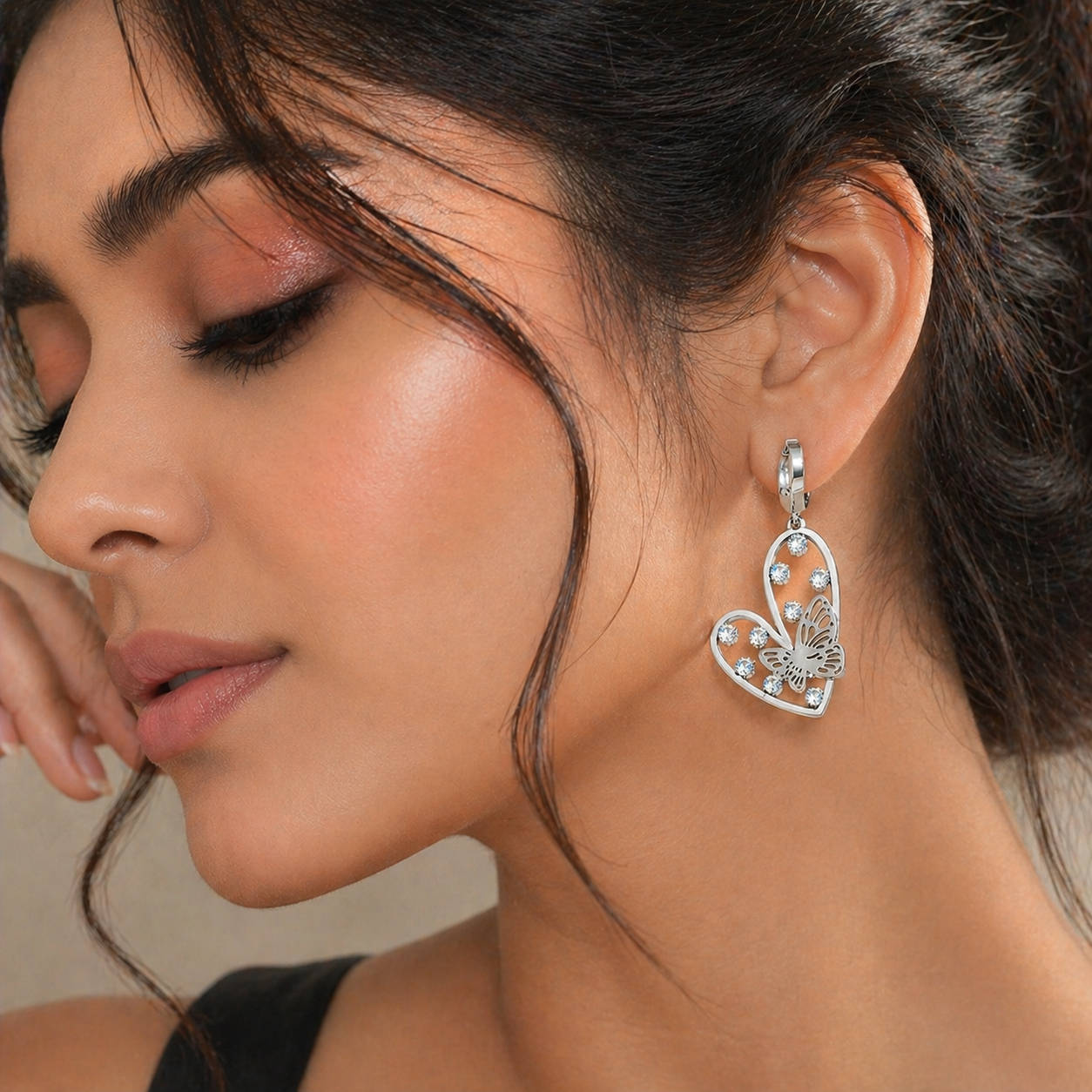 Silver-Toned Heart And Butterfly Drop Huggie Earrings With Rhinestone Accents.