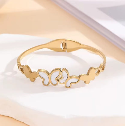 Gold plated Stainless Steel butterfly bangle bracelet with white inlay details.