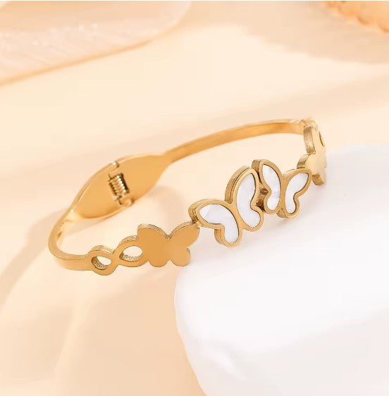 Gold plated Stainless Steel butterfly bangle bracelet with white inlay details.