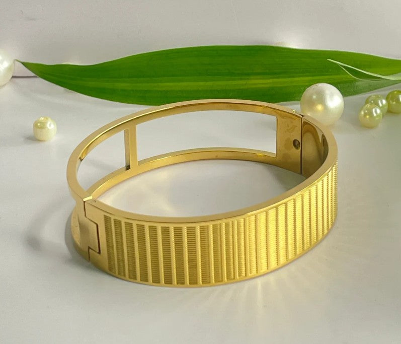 Gold plated Stainless Stell cuff bangle with a textured, linear pattern.