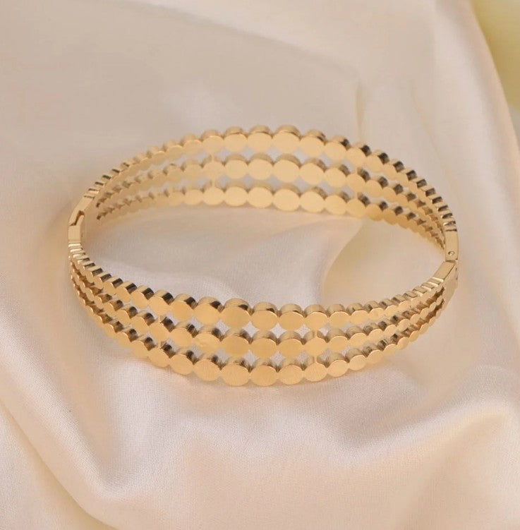 Gold plated Stainless Steel three-layered bangle bracelet featuring a cutout disc pattern